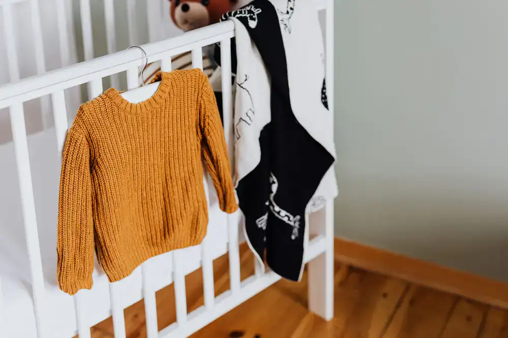Perchero con ropa infantil en tonos pastel