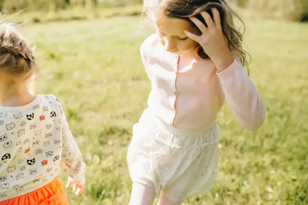 Dos niños corriendo y sonriendo con ropa holgada y cómoda en tonos pastel